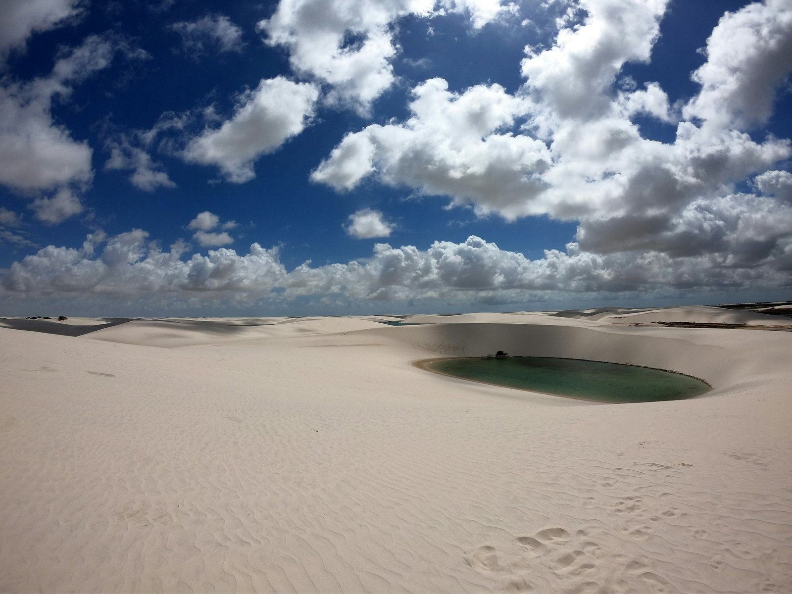Round lagoon under a dramatic sky, Lençóis Maranhenses